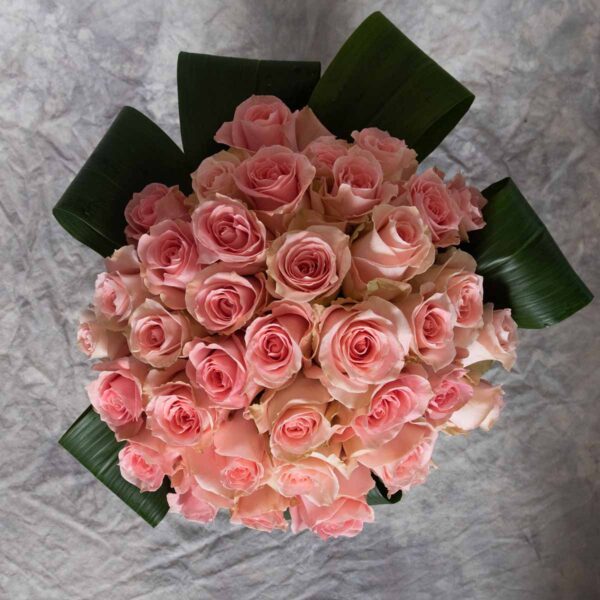 Top view of three dozen pink roses in a vase