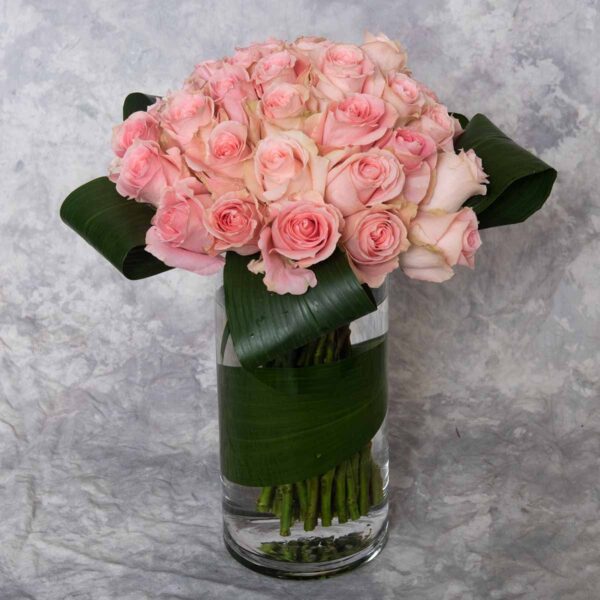 three dozen pink roses in a vase